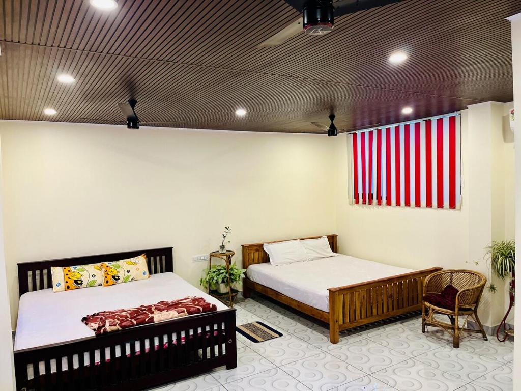 a bedroom with two beds and a chair in it at Mangattu Salkara highway view retreat in Anniyartholu