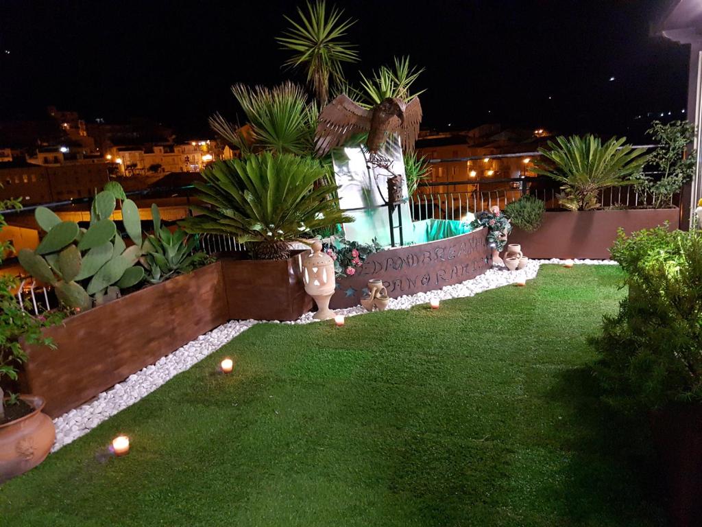 a garden at night with plants and a fountain at B&B Panoramic in Valguarnera Caropepe