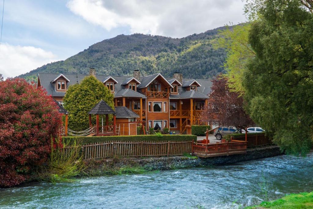 ein großes Haus am Ufer eines Flusses in der Unterkunft Cabañas centricas Rotui Patagonia Group in San Martín de los Andes