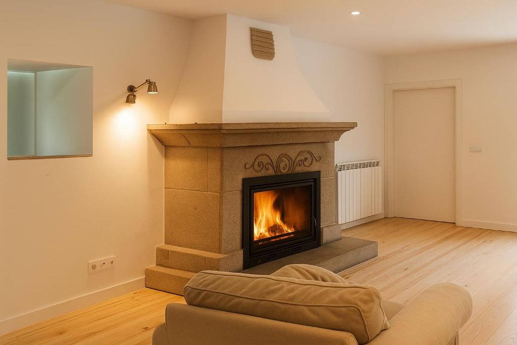 a fireplace in a living room with a couch at Casa Sayanes in Vigo