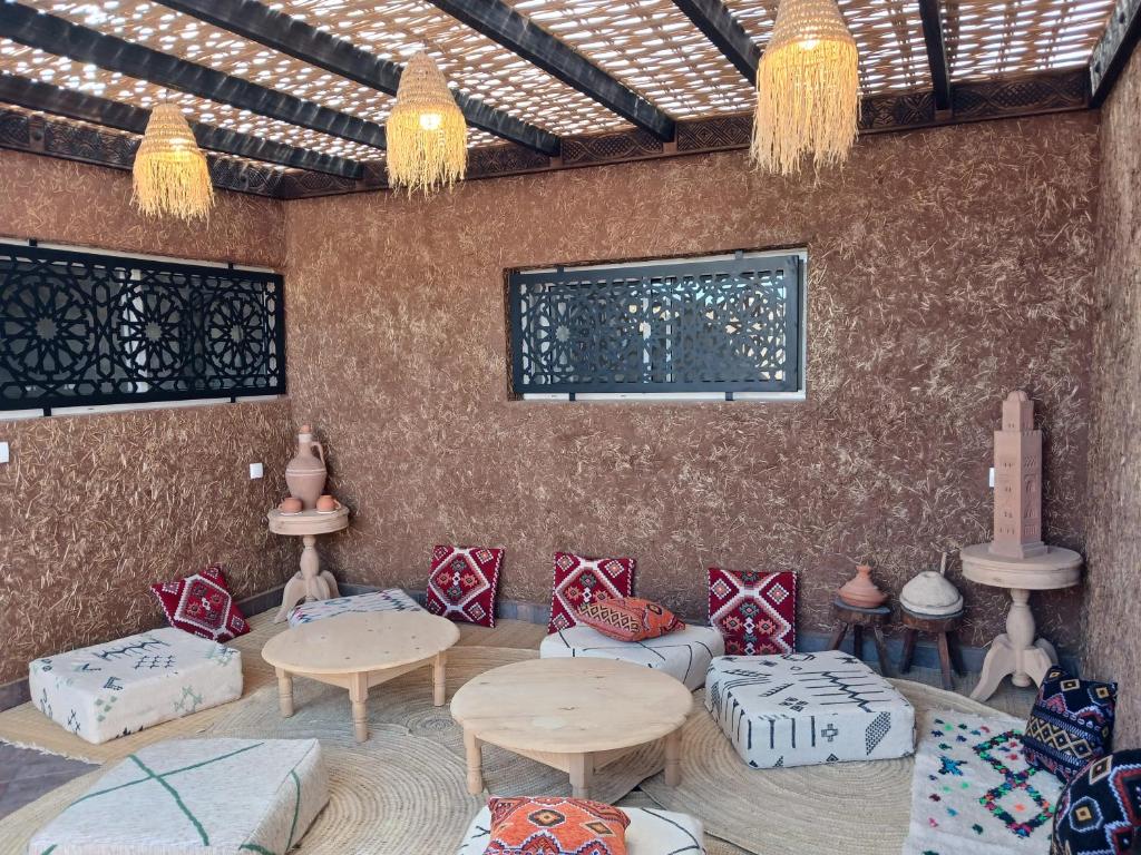 a room with tables and couches in a room at Maison almassira in Agadir