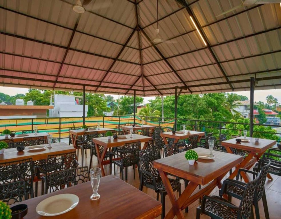 a restaurant with tables and chairs and a large umbrella at The Panakal Boho in Cochin