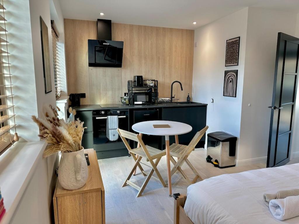 a room with a bed and a kitchen with a table at Eco-Friendly Highland Suite with Mountain Views in Spean Bridge