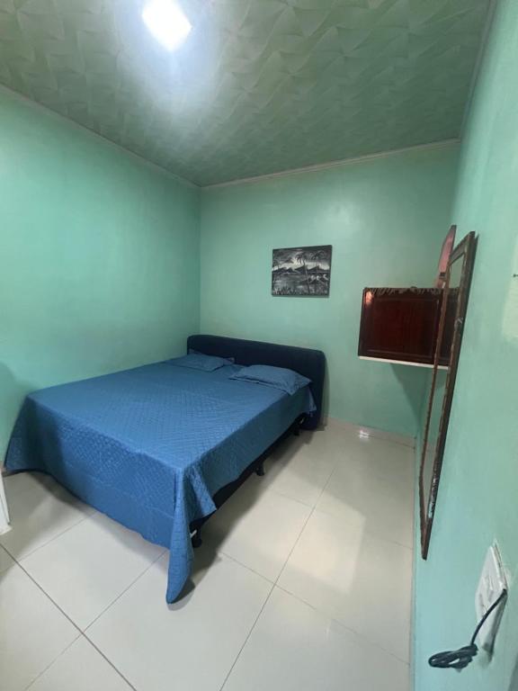 Un dormitorio con una cama azul en una habitación. en Quarto privativo,não é compartilhado!, en Parauapebas