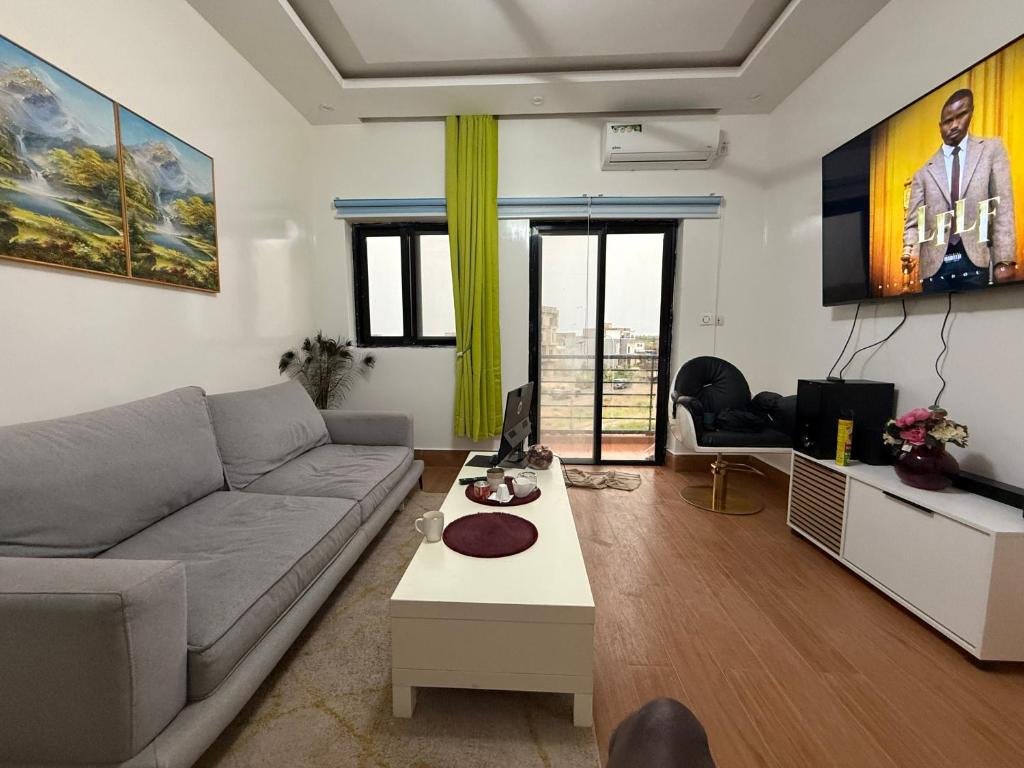 a living room with a couch and a tv at TWO M RÉSIDENCE M&M Thies ZAC Nguinth in Thiès