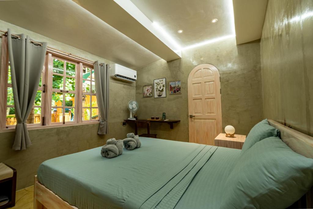 a bedroom with a bed with two stuffed animals on it at La Maison - Siquijor in Siquijor