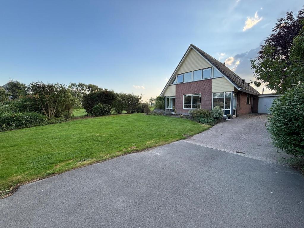 a house with a driveway in front of a yard at Bed & Boerderij 