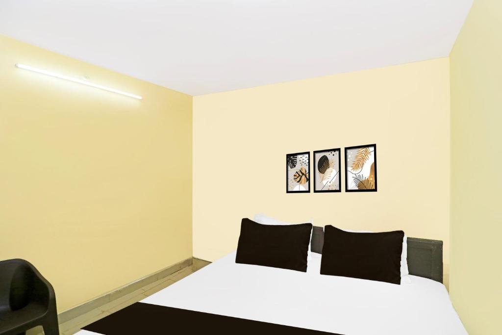 een slaapkamer met een wit bed met zwarte kussens bij Hotel O by OYO OXY RUDRA INN in Rānchī