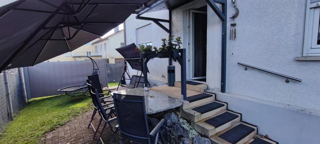 Un patio con una sombrilla y una mesa y sillas. en Infinity Ferienwohnung/Home, en Ostrach