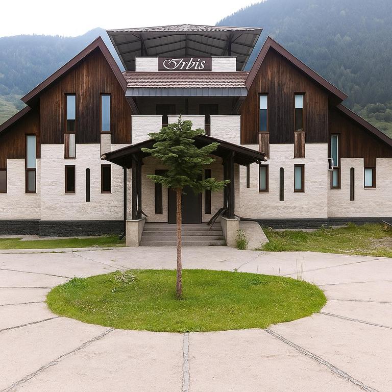 a building with a tree in front of it at Irbis hotel in Mestia