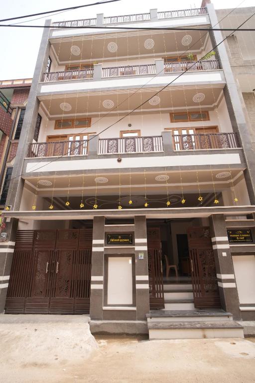 a building with brown doors and a balcony at Nidhipataye Homestay in Shivāpur