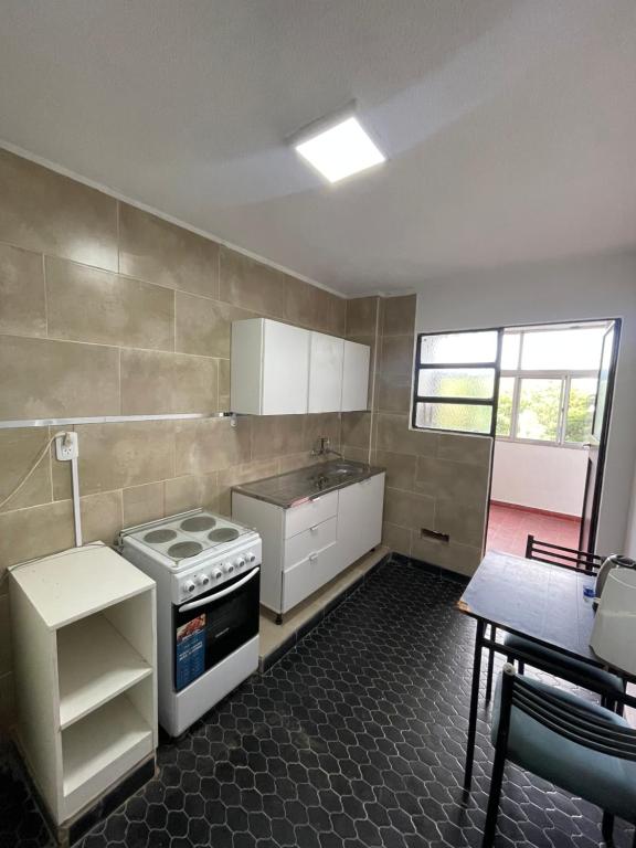 a small kitchen with a stove and a table at Marlu house in San Nicolás de los Arroyos