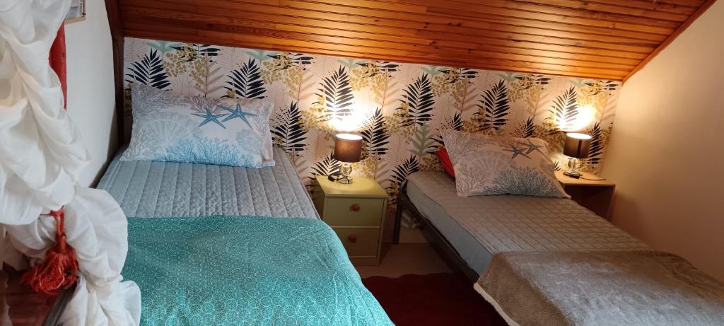 a bedroom with two beds and two lamps at chambre d'hôte la maison verte in Séglien