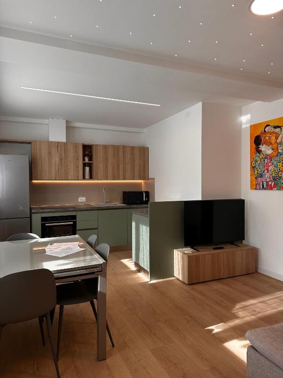 a living room with a table and a kitchen at Leonardo in Belluno