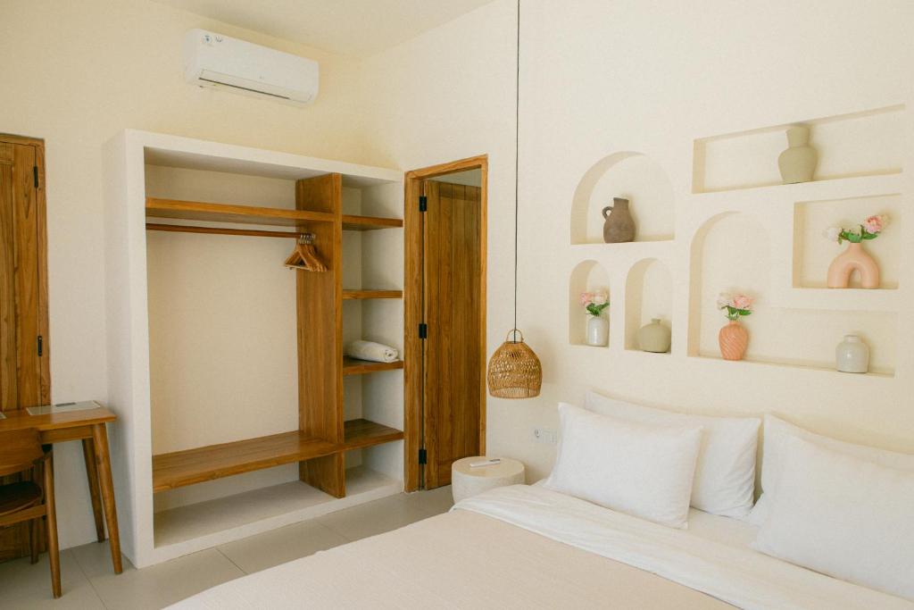 a bedroom with a bed and a desk and shelves at Turtle Villa 2 in Kuta Lombok
