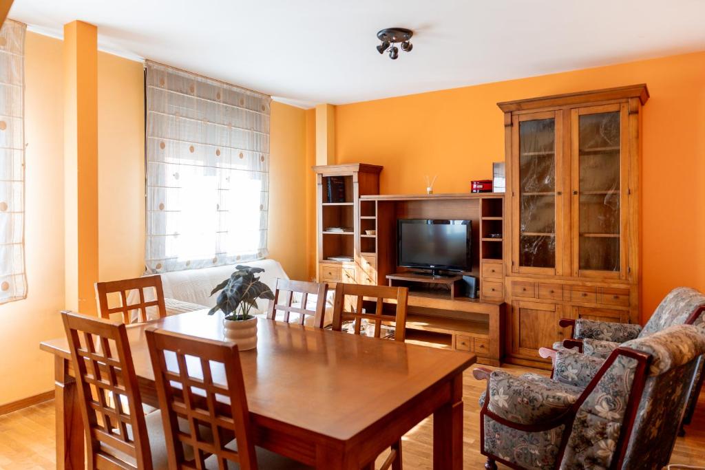 a living room with a dining table and a television at Asturica in Astorga