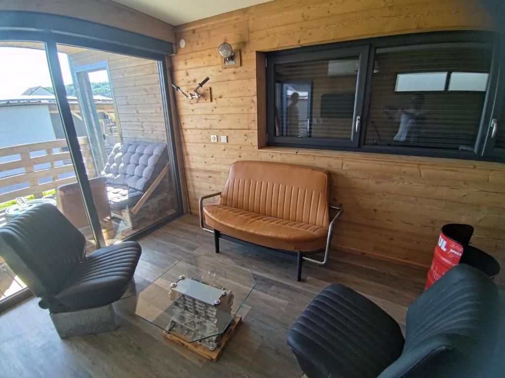 a living room with a couch and a chair at Mechanical cottage, old cars and bikes in Charmes
