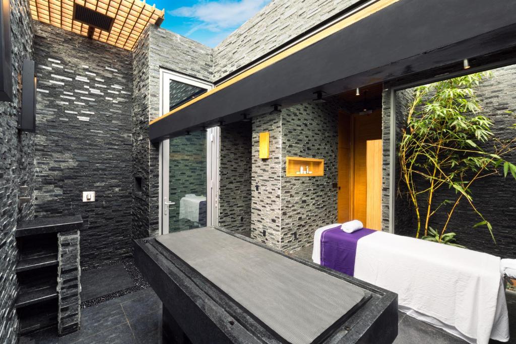 eine Außenterrasse mit Badewanne vor einem Gebäude in der Unterkunft Kokomo Ultra-Lux King - Single Cottage in Turtle Cove