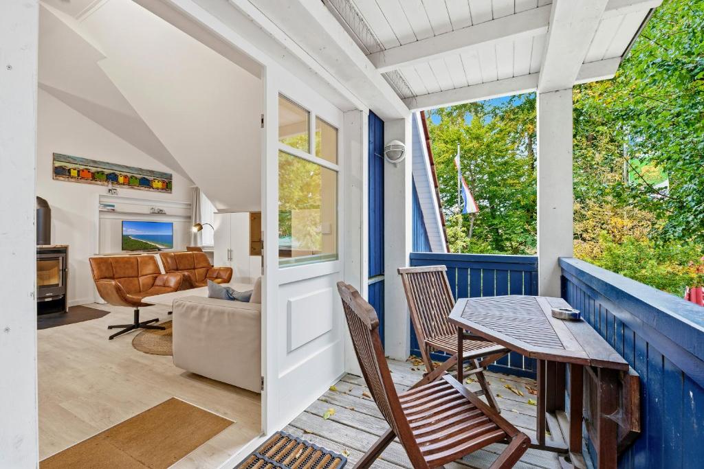 porche con mesa, sillas y sofá en Dünenhäuser Ückeritz UnserUsedomDe FeWo ca50qm mit Parkplatz direkt am Strand 12I3, en Ückeritz