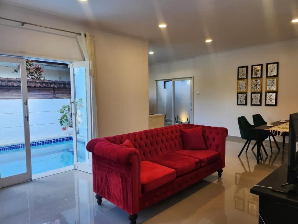 a red couch in a living room with a table at Bendesa Villa 14 in Ungasan