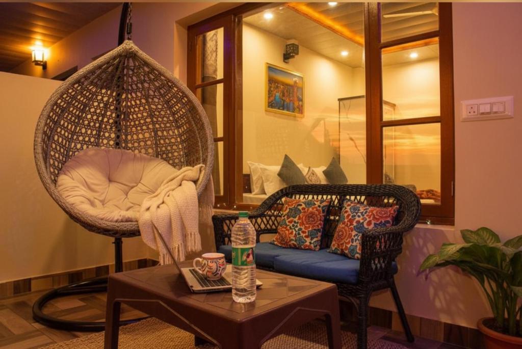 ein Raum mit einem Schaukelstuhl und einem Tisch in der Unterkunft Kasauli City Central Inn Hotel in Kasauli