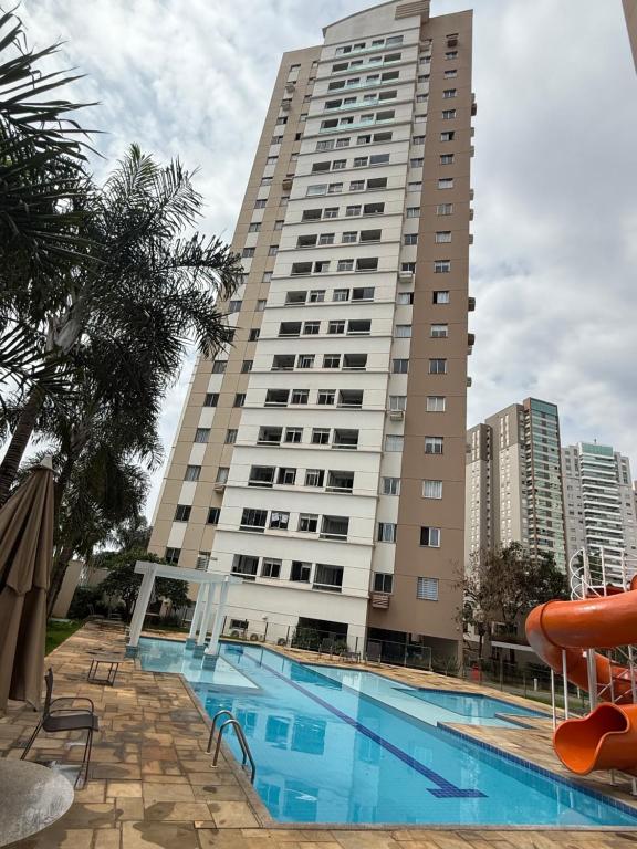 een gebouw met een zwembad voor een gebouw bij Recanto Augusta in Londrina