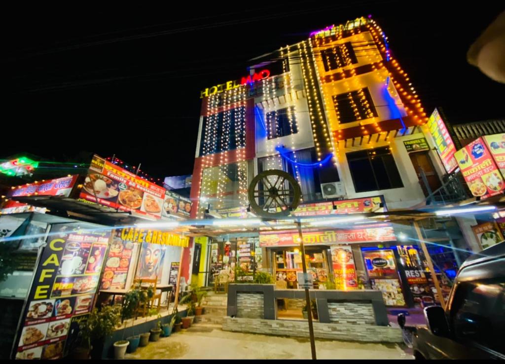 a building with neon signs in front of it at night at Hotel MAQ Lumbini in Lumbini