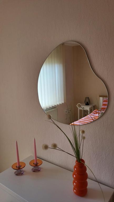 a vase with two candles on a table with a mirror at Casa Bölts in Heltersberg