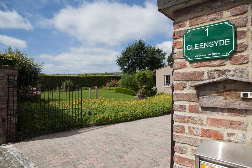 a green sign on the side of a brick building at Cleensyde in Horebeke