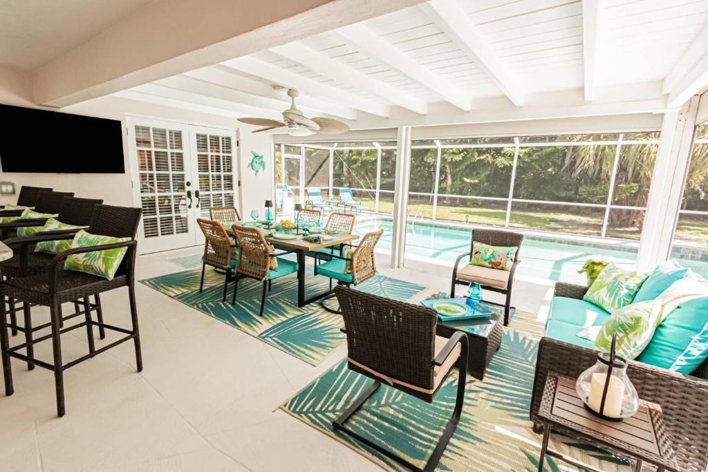 a patio with a table and chairs and a pool at Oleander Drive - Coquina Sands in Naples