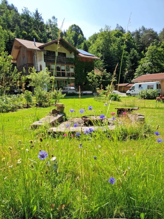 a yard with flowers in front of a house at Waldbach-Oase in Thurmansbang