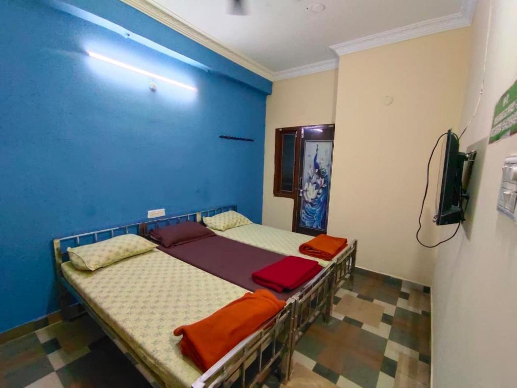 a bedroom with two beds and a blue wall at SriShivaShankari GuestHouse in Hyderabad