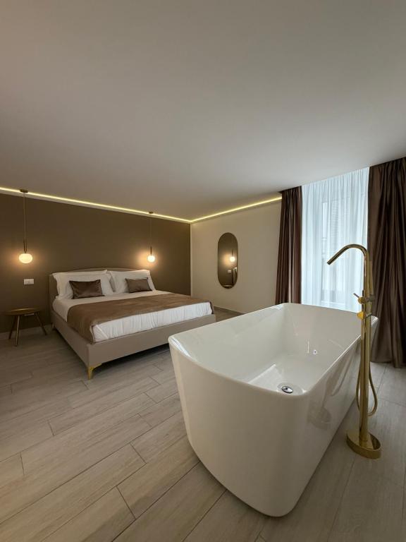 a large bathroom with a tub in front of a bed at Seraphia Apartment in Palermo