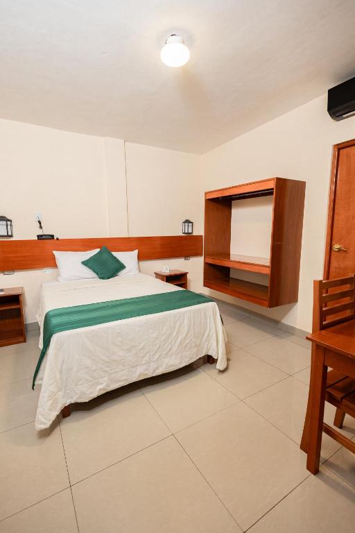 a bedroom with a large bed and a desk at Tariri Hotel in Pucallpa