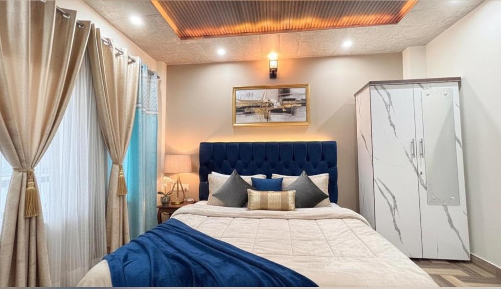 a bedroom with a king sized bed with a blue headboard at The Forever Retreat Kasauli by Splendid Hotels in Dharampur