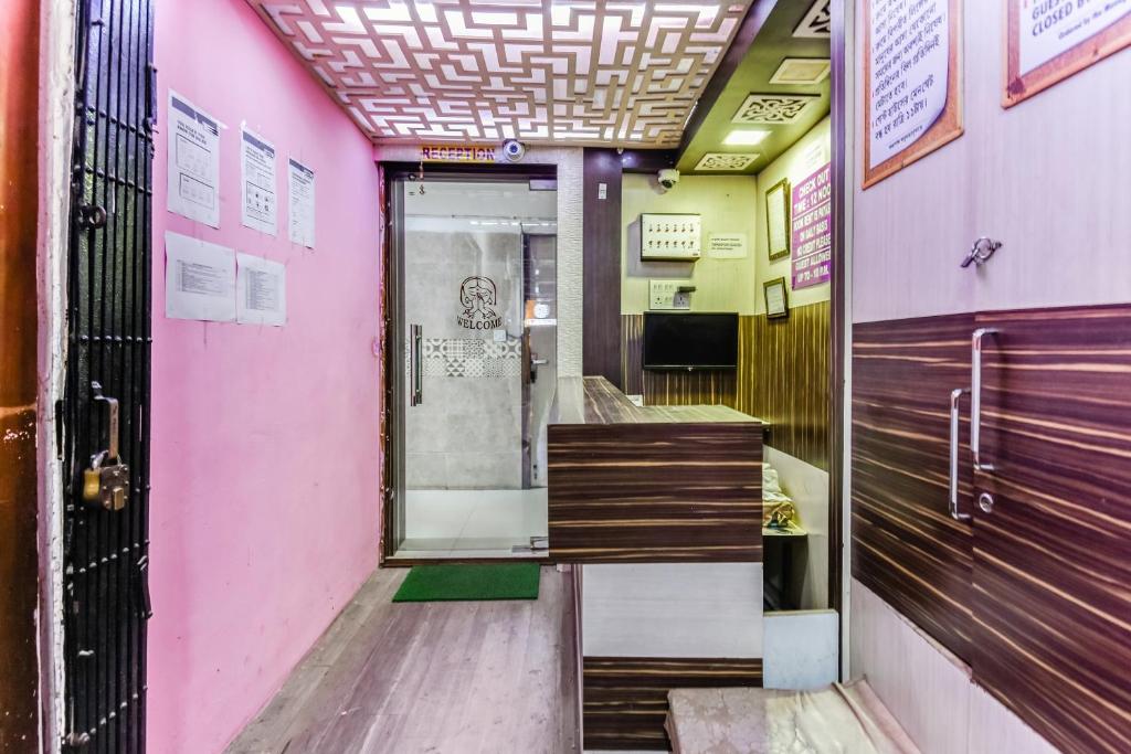 a corridor of a pink building with a door at Hotel O A One Guest House in Kolkata