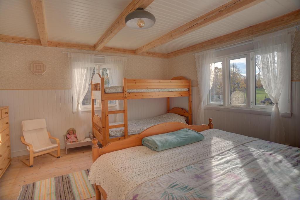 a bedroom with a bunk bed and a chair at Sommargyllen Torp Brändabo in Torsås
