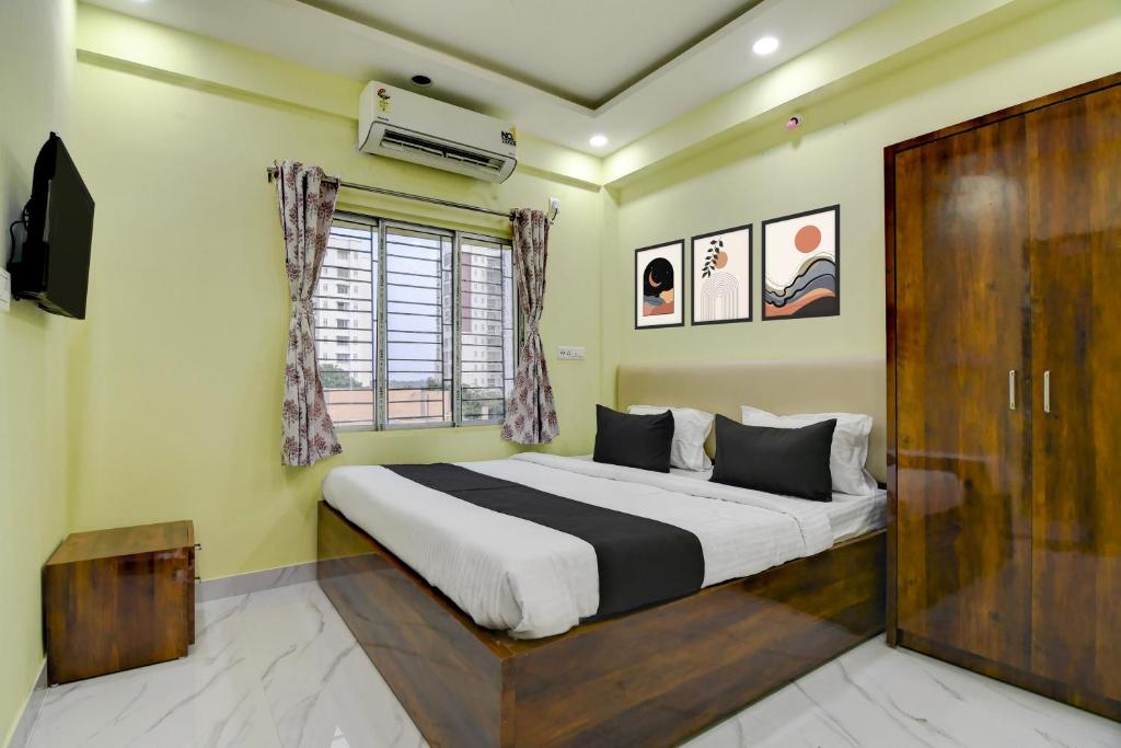 a bedroom with a large bed and a window at Hotel O Jerry Guest House & Caf� By CheckIn in Bishnupur