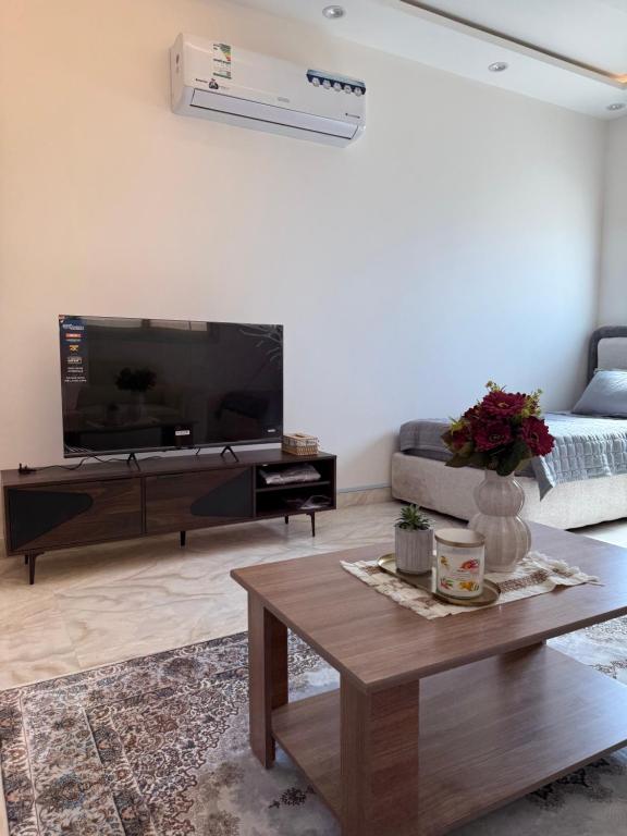 a living room with a large television and a coffee table at Apartment in Tabuk