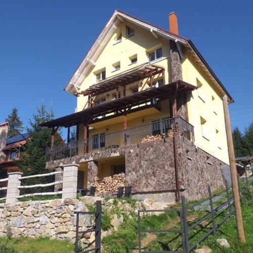 a large house on top of a stone wall at Vila Altapura in Păltiniş