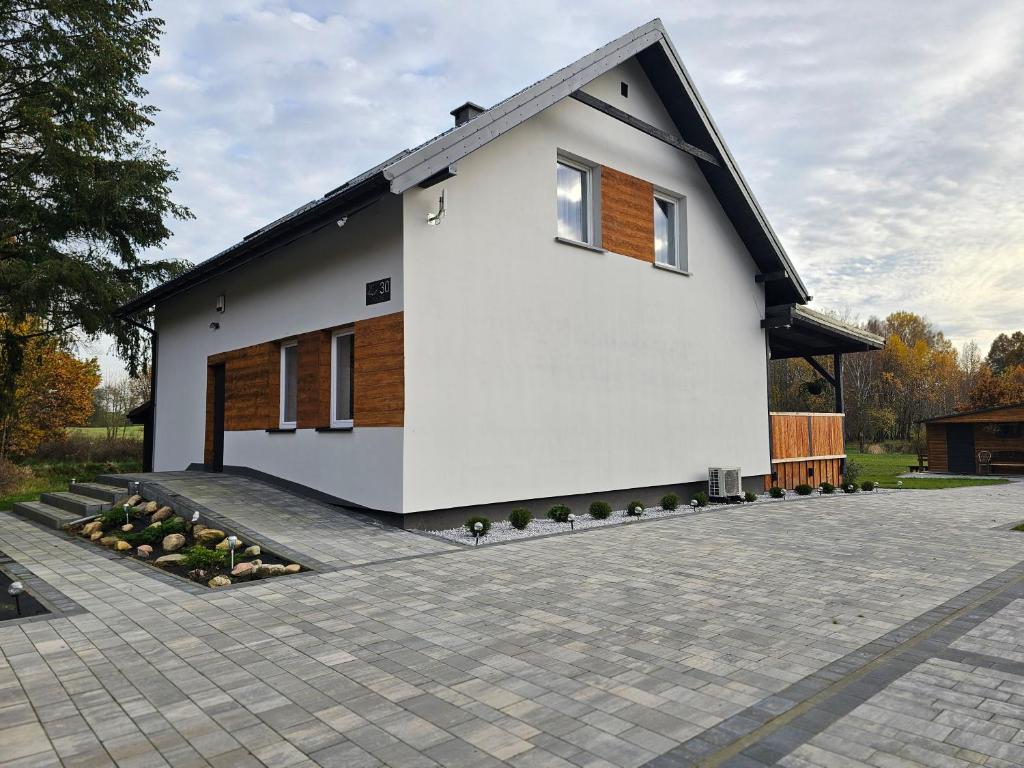 a white house with a driveway in front of it at Ostoja SOWIBÓR in Dołgie