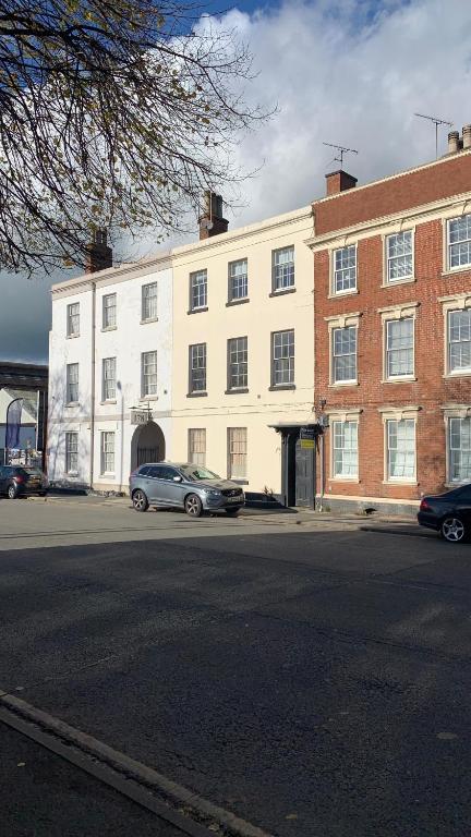 a large white building with cars parked in front of it at Burton Down Town Apartment in Burton upon Trent
