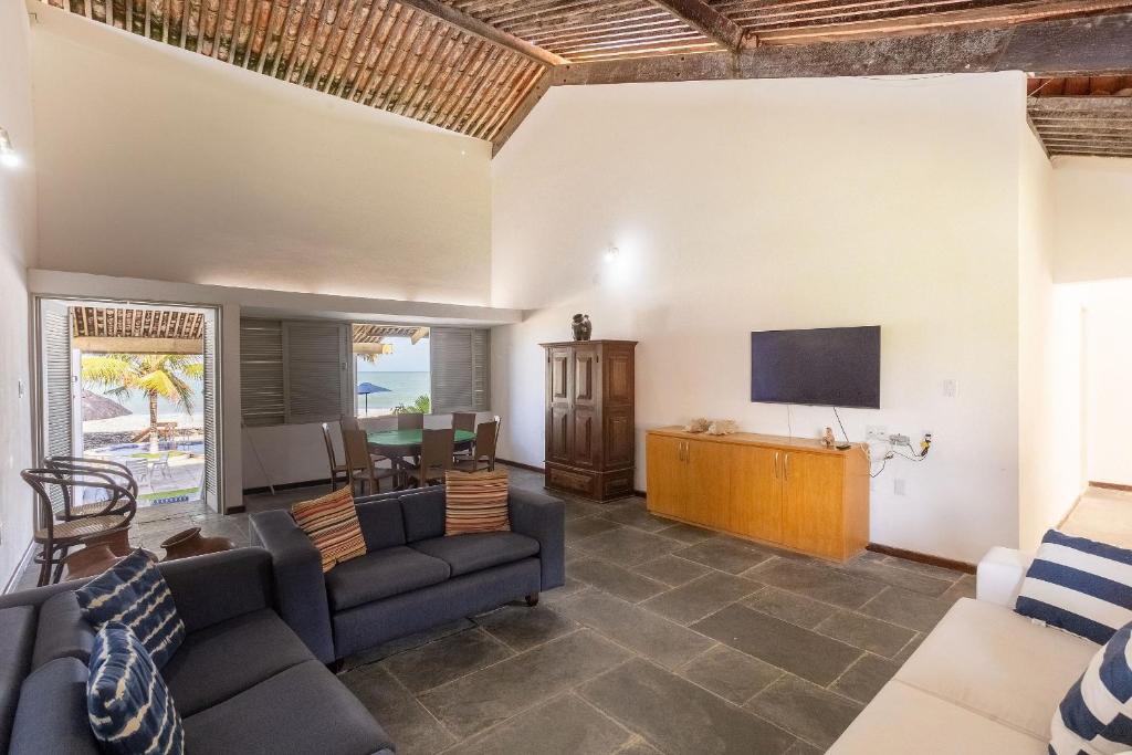 a living room with a couch and a tv at Cohost Casa Pedra do Anel in Vila Velha