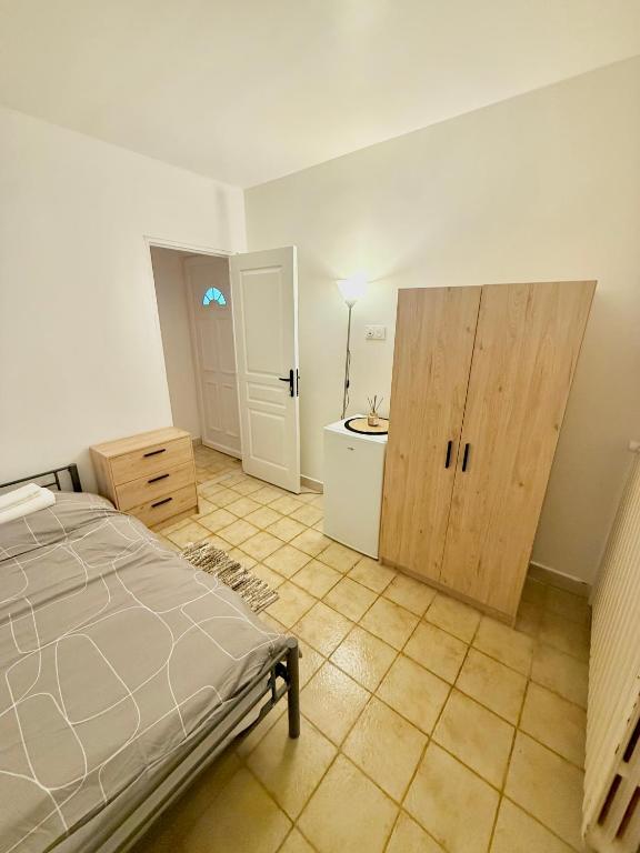 a bedroom with a bed and a bathroom with a sink at Maison Bon Séjour in Livry-Gargan