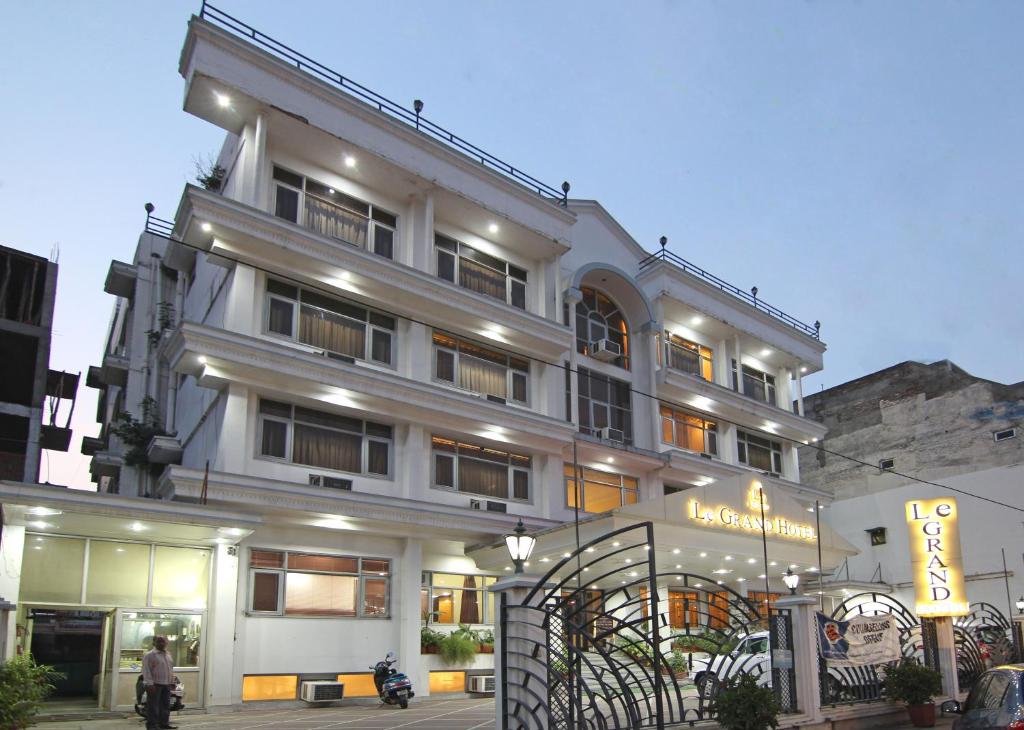 un edificio blanco con un cartel delante en Le Grand Hotel, en Haridwar
