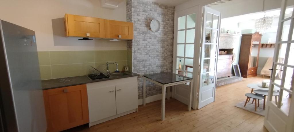 a kitchen with white cabinets and a counter top at Jura entre Lacs et Montagnes Charmant studio cosy de 38 m2 in Orgelet