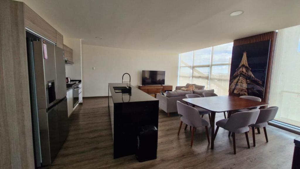 eine Küche und ein Wohnzimmer mit einem Tisch und einer Couch in der Unterkunft Departamento en Angelópolis in El Gallinero