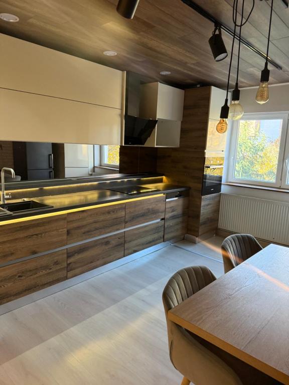 een keuken met houten kasten en een houten tafel bij Apartament Str Crinului Cluj in Cluj-Napoca