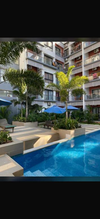 a swimming pool in front of a large apartment building at Aquaview in Bijilo
