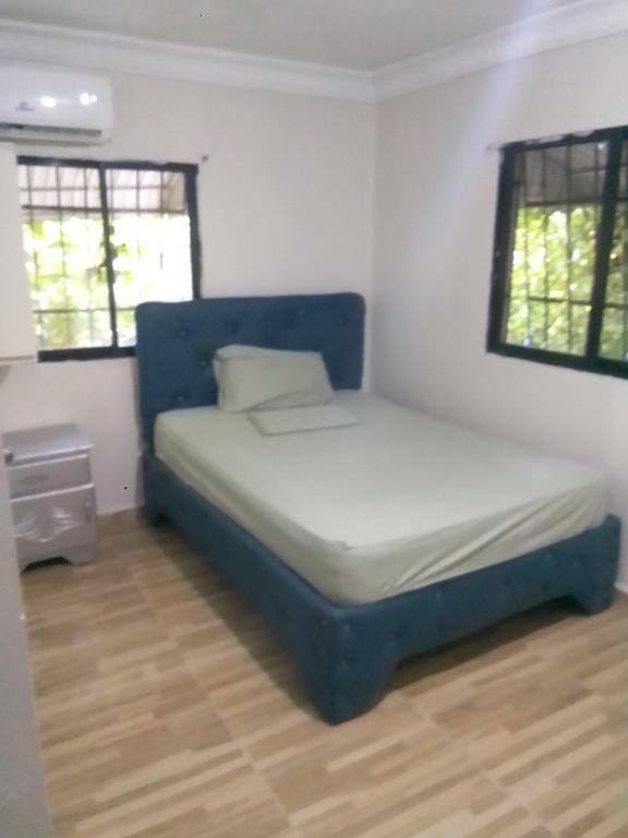 a bedroom with a blue bed in a room at La Casa de Manccini in Santo Domingo